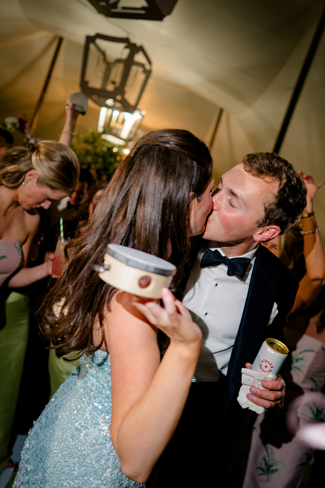 Bride and groom kiss on the dance floor during wedding reception. 