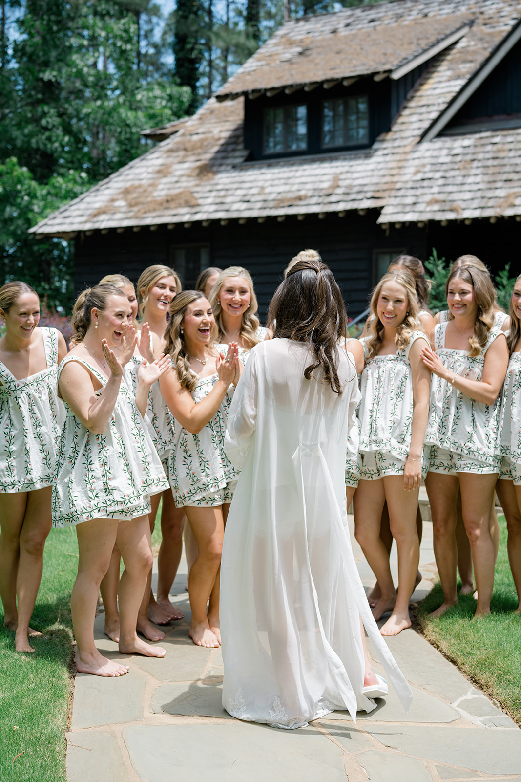 Bridesmaids in matching pajamas clapping for the bride.