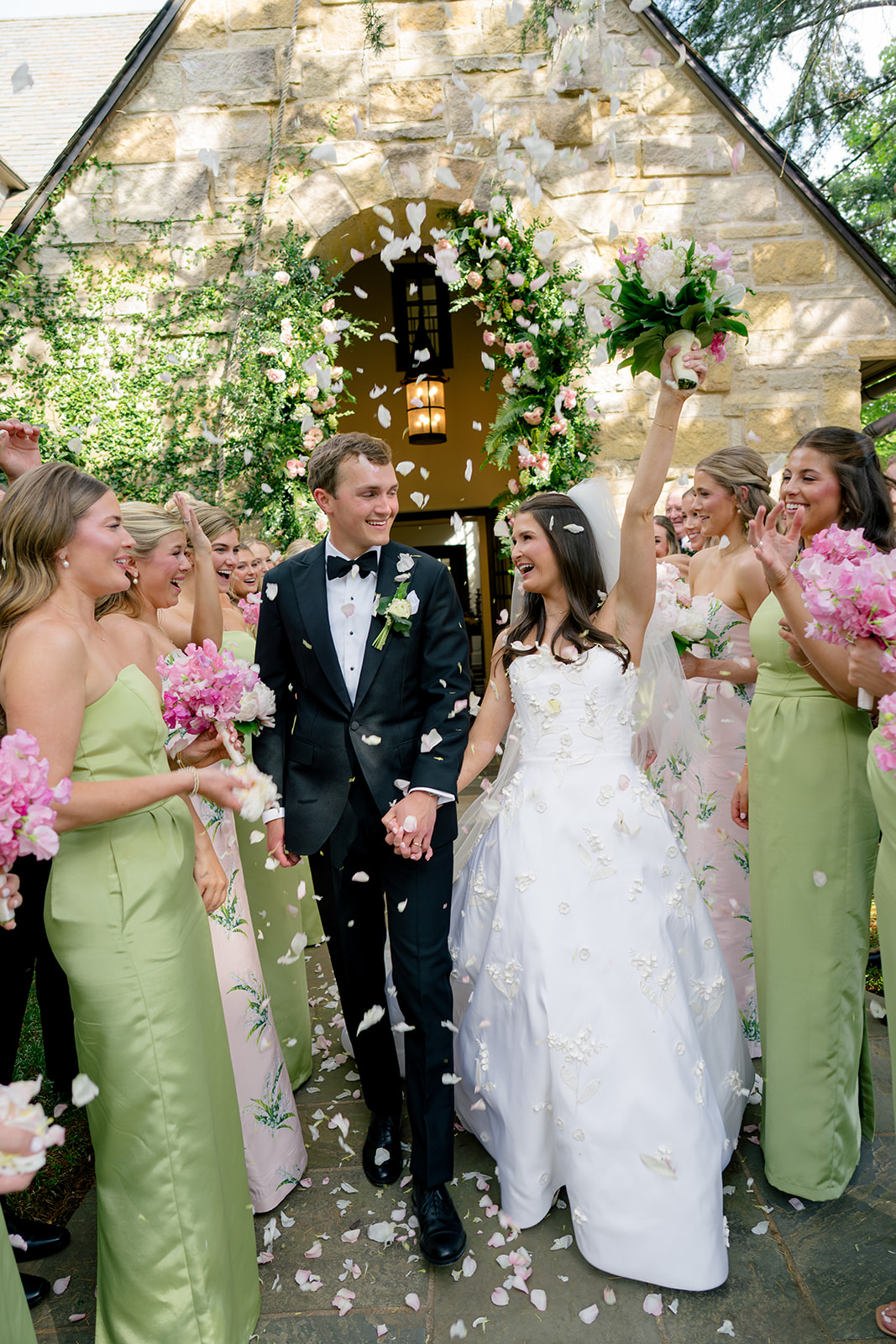 Flower petal toss ceremony exit with bridal party laughing and throwing flowers.