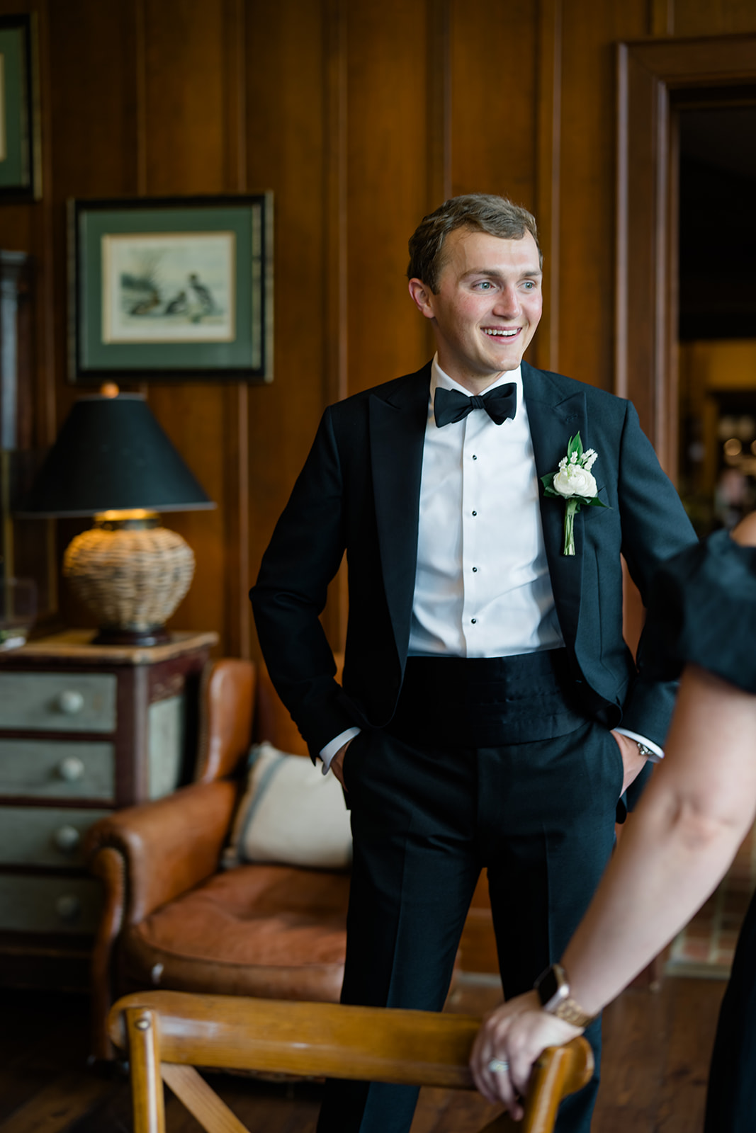 Groom on the morning on his wedding smiling with hands in his pockets.