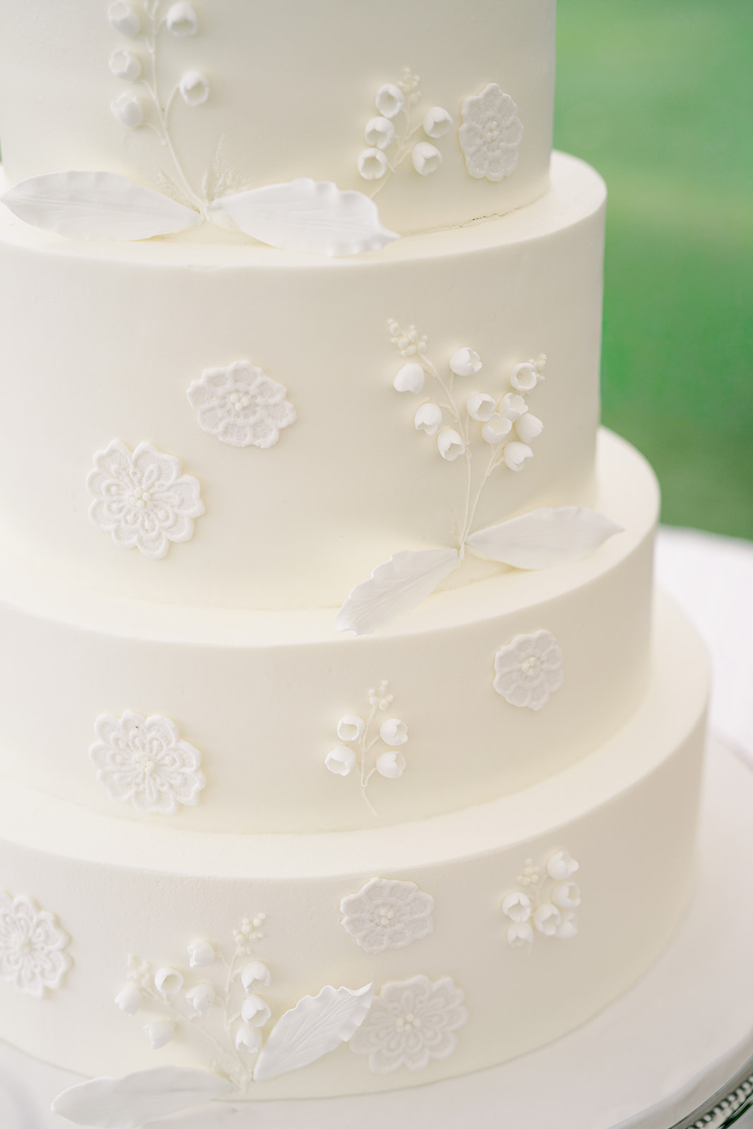 5 tier wedding cake with lilly of the valley design.